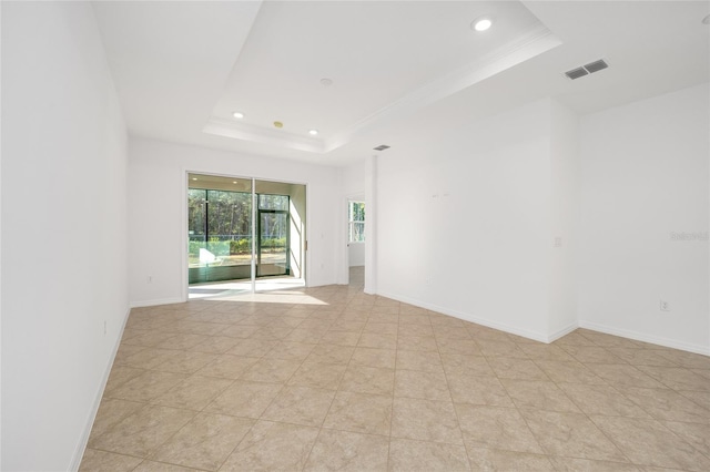 spare room with crown molding and a raised ceiling