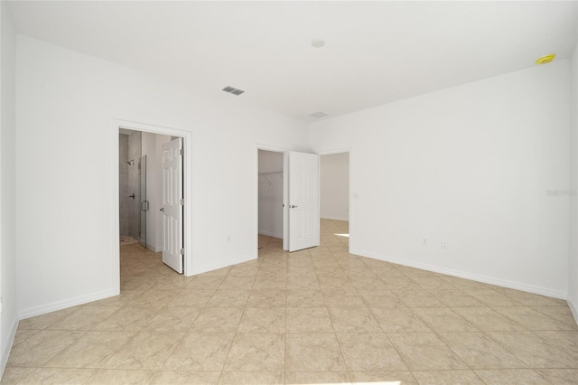 unfurnished bedroom featuring a spacious closet and a closet