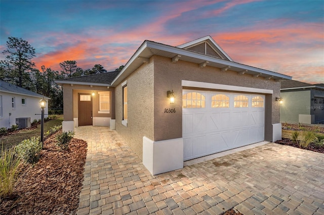 view of front of home featuring cooling unit and a garage