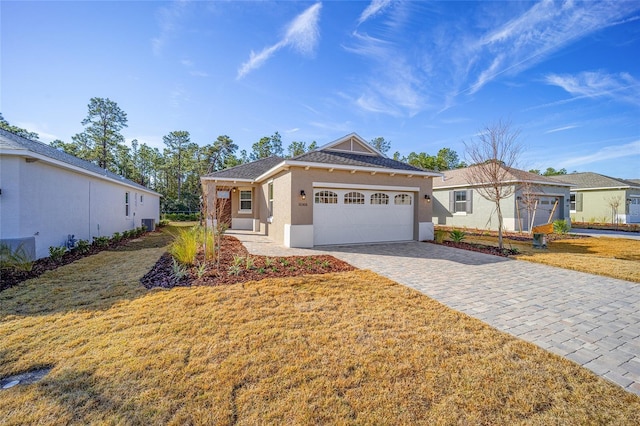 single story home featuring a garage and a front lawn