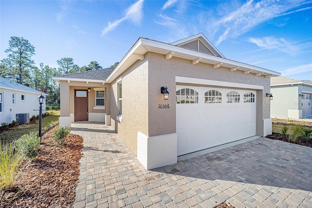 view of front of house featuring a garage and central AC