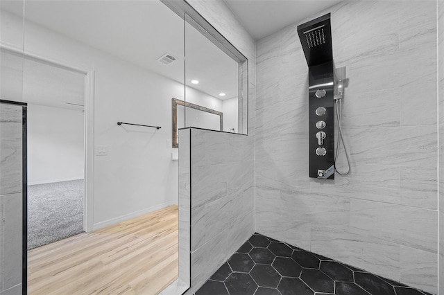 bathroom featuring a tile shower and hardwood / wood-style flooring