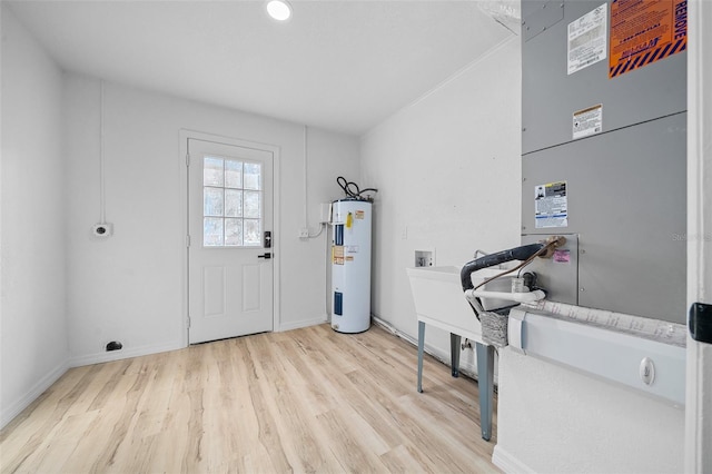 interior space with electric water heater and light hardwood / wood-style flooring