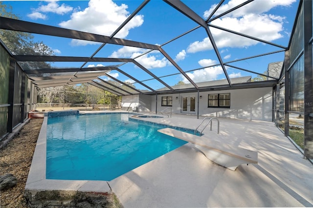 view of swimming pool with a diving board, a patio area, glass enclosure, and french doors