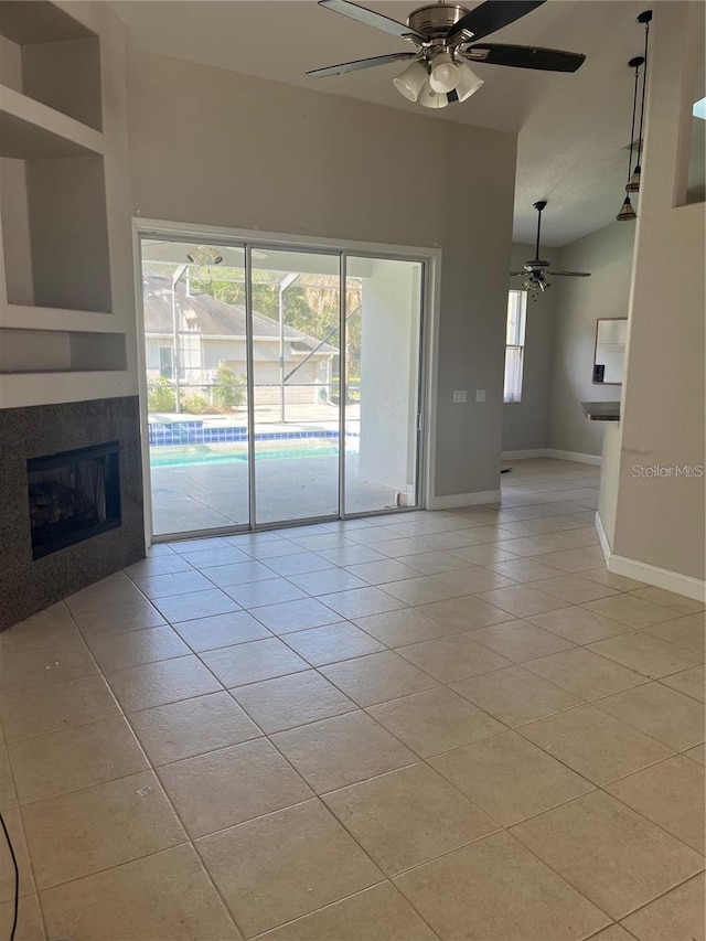 unfurnished living room featuring light tile patterned floors, a tile fireplace, and ceiling fan