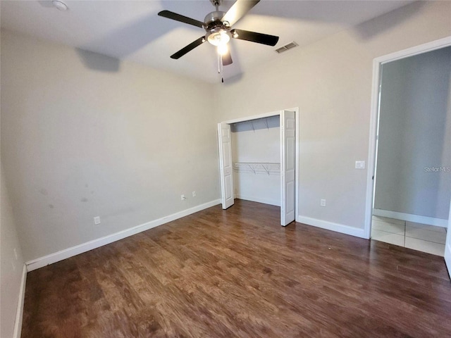 unfurnished bedroom with dark hardwood / wood-style floors, ceiling fan, and a closet