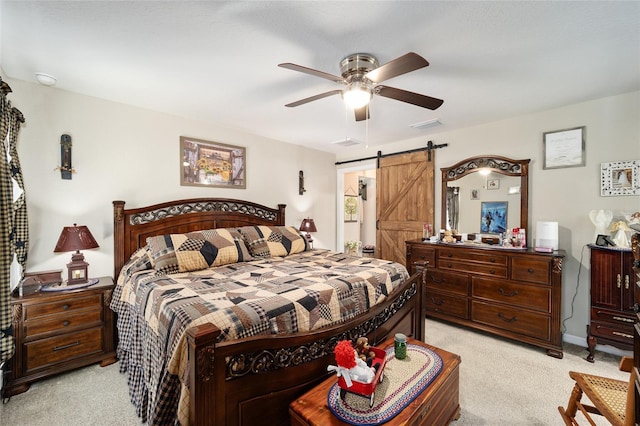 bedroom featuring a barn door, light carpet, and ceiling fan