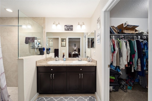 bathroom featuring a tile shower and vanity