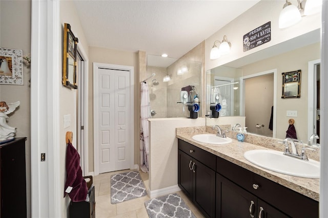 bathroom with vanity, tile patterned floors, a shower with door, and a textured ceiling