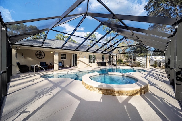 view of pool with an in ground hot tub, a patio area, and glass enclosure