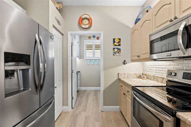 kitchen with lofted ceiling, backsplash, light hardwood / wood-style floors, and appliances with stainless steel finishes