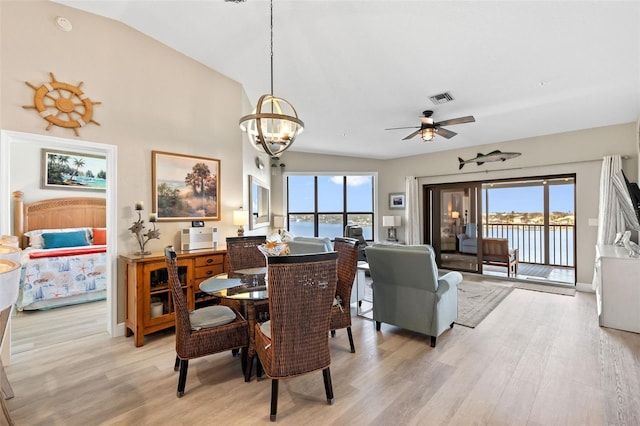 dining space with a water view, light hardwood / wood-style flooring, and a wealth of natural light