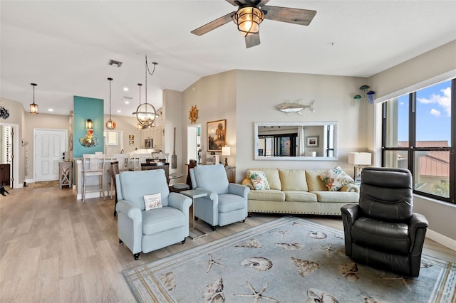 living room featuring vaulted ceiling, ceiling fan, and light wood-type flooring