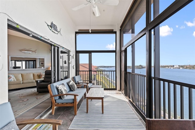 sunroom featuring a water view and ceiling fan