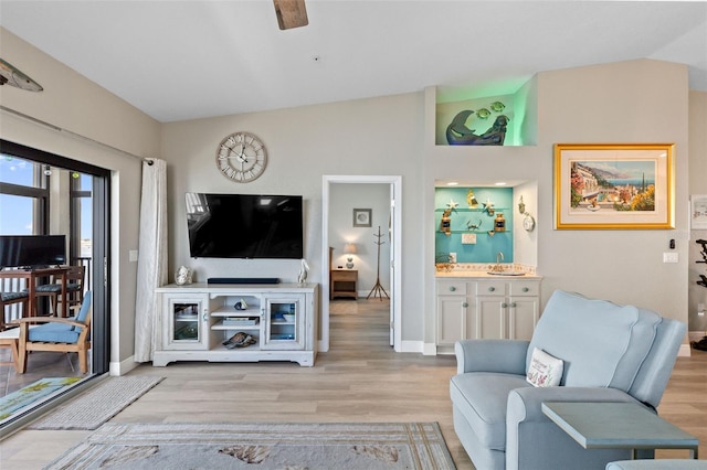 living room with lofted ceiling, light hardwood / wood-style floors, ceiling fan, and bar area