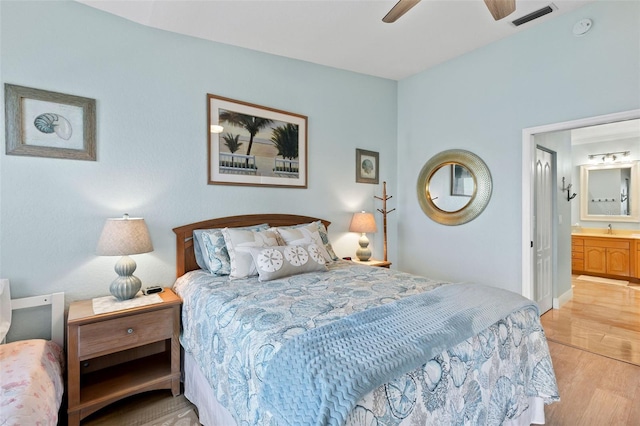 bedroom with ceiling fan, ensuite bath, sink, and light wood-type flooring