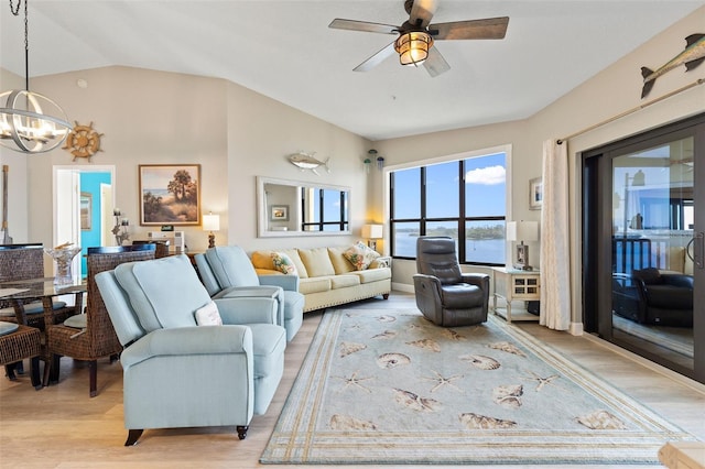 living room featuring lofted ceiling, ceiling fan with notable chandelier, and light hardwood / wood-style flooring