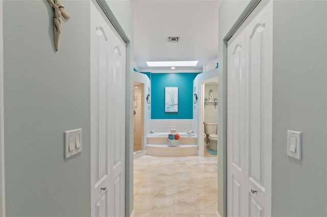 bathroom with a tub to relax in and toilet