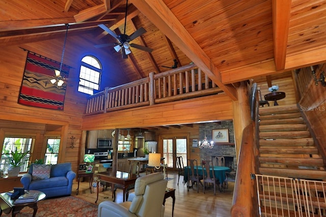 living room featuring plenty of natural light, ceiling fan, and wood walls