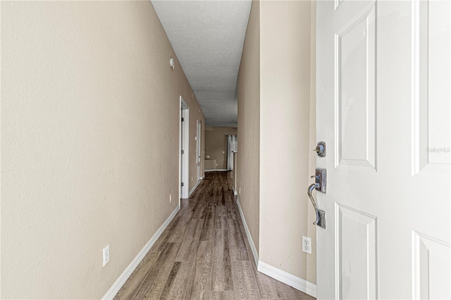 hallway with wood-type flooring and a textured ceiling