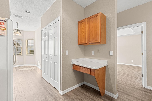 interior space with a textured ceiling and light wood-type flooring