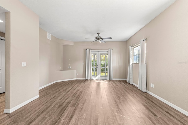 spare room with hardwood / wood-style floors, ceiling fan, and french doors