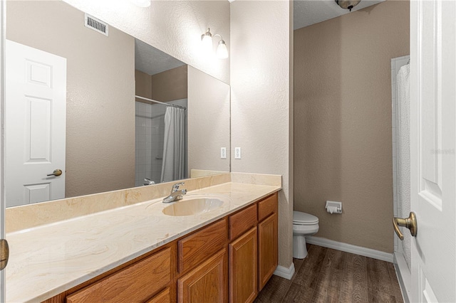 bathroom with wood-type flooring, toilet, curtained shower, and vanity