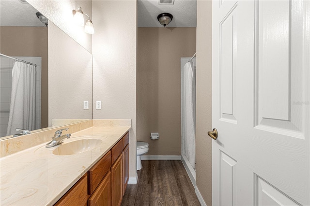 bathroom with vanity, hardwood / wood-style flooring, toilet, and a textured ceiling