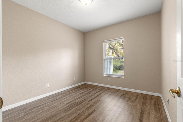 spare room with hardwood / wood-style flooring and a textured ceiling