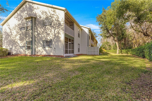 back of house featuring a yard, a balcony, and central air condition unit