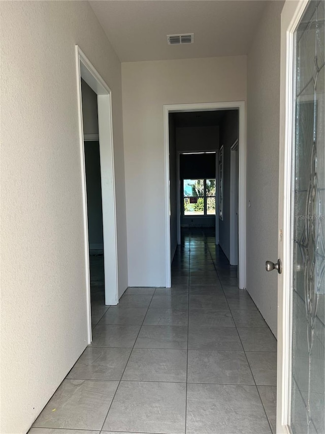 hall with tile patterned floors