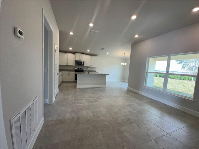 kitchen featuring baseboards, appliances with stainless steel finishes, visible vents, and a sink