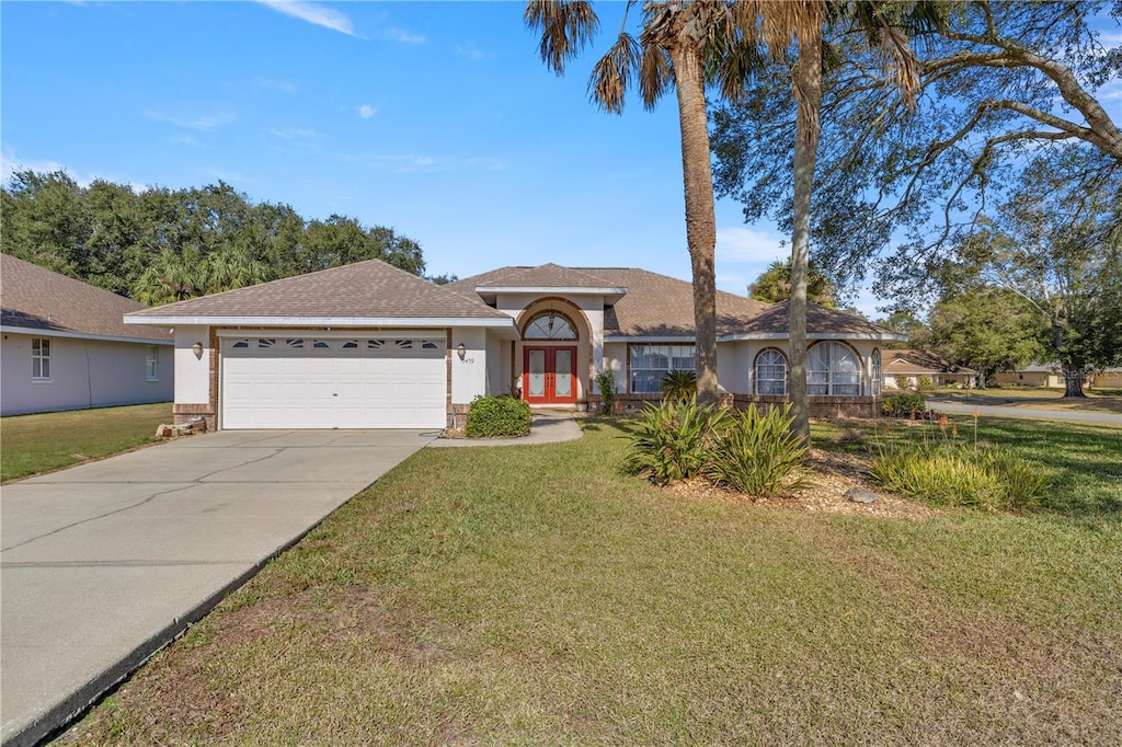 ranch-style home featuring a garage and a front yard