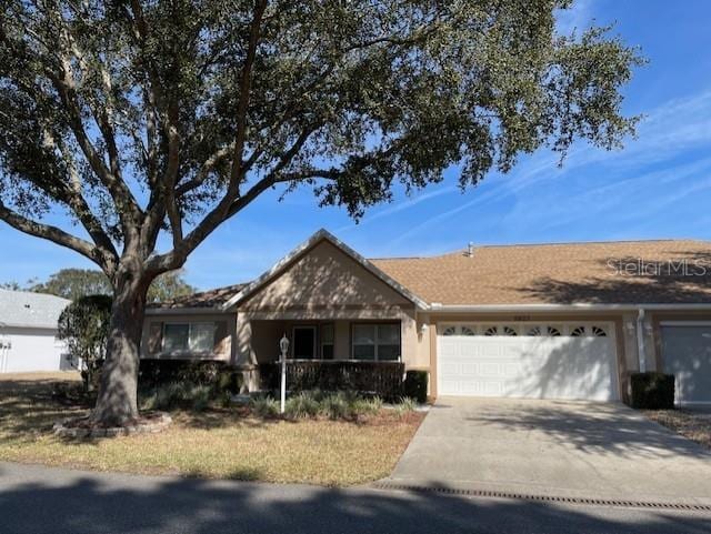 single story home featuring concrete driveway, an attached garage, a porch, and stucco siding