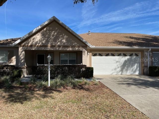 ranch-style home with a garage and a front lawn