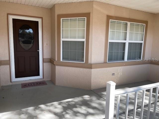 entrance to property featuring stucco siding