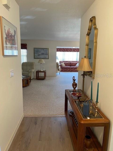 hall with hardwood / wood-style flooring and a textured ceiling