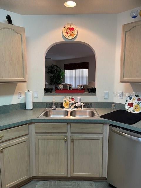 kitchen with light brown cabinetry, sink, and dishwasher