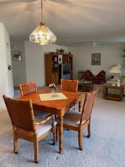 dining area featuring ceiling fan and carpet flooring