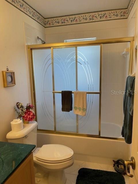 bathroom featuring combined bath / shower with glass door, toilet, vanity, and tile patterned floors