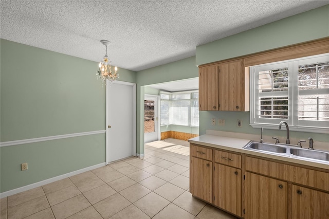 kitchen with pendant lighting, an inviting chandelier, sink, light tile patterned floors, and a textured ceiling