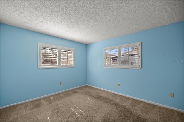 carpeted spare room featuring a textured ceiling