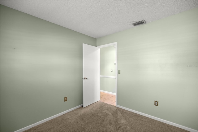 carpeted spare room with a textured ceiling