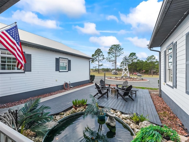 wooden deck featuring an outdoor fire pit