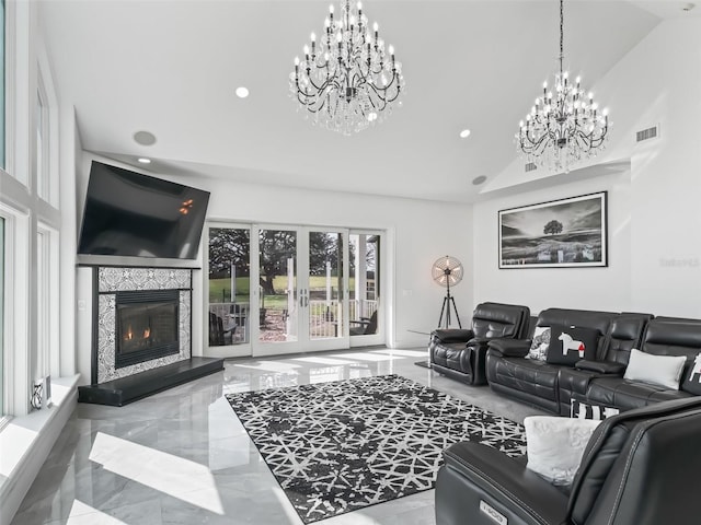 living room featuring vaulted ceiling, a chandelier, a fireplace, and french doors