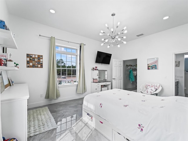 bedroom with a walk in closet and a chandelier