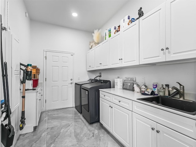 laundry room featuring cabinets, sink, and washer and clothes dryer