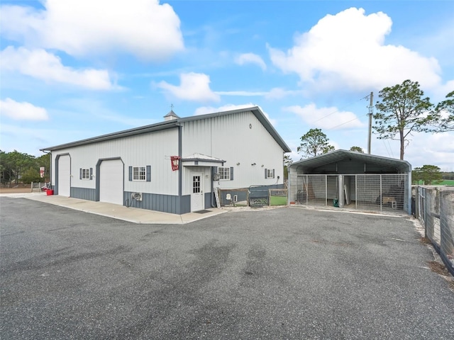 view of side of home featuring a carport, a garage, and an outbuilding