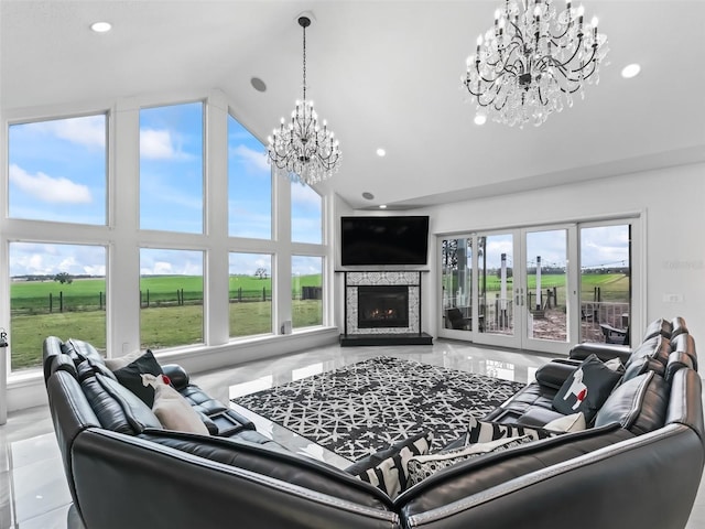 living room with recessed lighting, french doors, high vaulted ceiling, a warm lit fireplace, and a notable chandelier