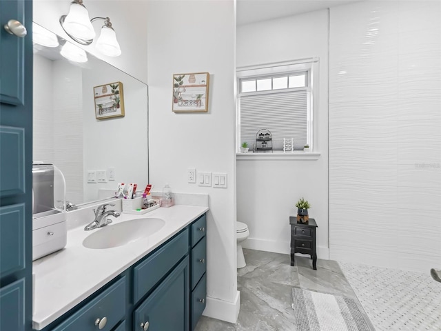 full bath featuring toilet, vanity, and baseboards